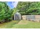 Well-maintained backyard with storage shed, stone sitting area, and privacy fence at 1211 Chapel Estates Way, Dacula, GA 30019