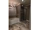 Beautiful bathroom featuring a soaking tub, glass shower, chandelier, and a marble floor at 1211 Chapel Estates Way, Dacula, GA 30019