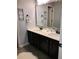 Modern bathroom with double sinks, dark cabinets and decorative mosaic-framed mirror at 1211 Chapel Estates Way, Dacula, GA 30019