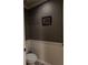 Cozy powder room with wainscotting, blue paint and a decorative mirror above the toilet at 1211 Chapel Estates Way, Dacula, GA 30019