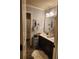 A well-lit bathroom with granite counter tops and double sinks and a shower in the background at 1211 Chapel Estates Way, Dacula, GA 30019