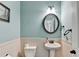 Charming half bathroom with blue walls, classic bead-board wainscoting, and a pedestal sink with modern fixtures at 1211 Chapel Estates Way, Dacula, GA 30019