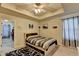 Comfortable bedroom with decorative tray ceiling, carpeted floor, and view of large closet at 1211 Chapel Estates Way, Dacula, GA 30019
