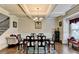 Formal dining room with coffered ceilings, wainscoting, chandelier, hardwood floors, and staircase at 1211 Chapel Estates Way, Dacula, GA 30019