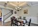 Formal dining room with coffered ceilings, wainscoting, chandelier, hardwood floors, and staircase at 1211 Chapel Estates Way, Dacula, GA 30019