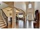 Spacious foyer with soaring ceilings, beautiful hardwood floors, decorative bench, and open staircase at 1211 Chapel Estates Way, Dacula, GA 30019