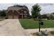 Beautiful brick home showcasing manicured front yard and a lengthy driveway leading to a two-car garage at 1211 Chapel Estates Way, Dacula, GA 30019