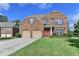 Inviting two-story brick home featuring a red front door, attached two-car garage and well-maintained lawn at 1211 Chapel Estates Way, Dacula, GA 30019