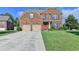 Inviting two-story brick home featuring a red front door, attached two-car garage and well-maintained lawn at 1211 Chapel Estates Way, Dacula, GA 30019