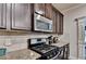 This kitchen boasts stainless steel appliances and granite countertops with dark wood cabinets at 1211 Chapel Estates Way, Dacula, GA 30019