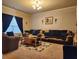 Inviting living room featuring a plush sofa, dark blue curtains, a neutral color palette and lots of natural light at 1211 Chapel Estates Way, Dacula, GA 30019