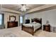 Spacious main bedroom features tray ceilings, carpet, and stylish ceiling fan with elegant light fixture at 1211 Chapel Estates Way, Dacula, GA 30019