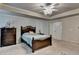 This is a carpeted main bedroom featuring a bed, dresser and stylish ceiling fan with light fixture at 1211 Chapel Estates Way, Dacula, GA 30019