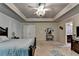 This is a carpeted main bedroom featuring a bed, dresser and stylish ceiling fan with light fixture at 1211 Chapel Estates Way, Dacula, GA 30019