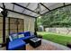 Cozy covered patio featuring stylish furnishings, a decorative rug, and a serene view of the lush backyard at 1211 Chapel Estates Way, Dacula, GA 30019
