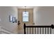 Staircase with a light fixture hanging above a window and multiple photos hanging on the wall at 1211 Chapel Estates Way, Dacula, GA 30019