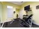 Home weight room featuring a workout bench, free weights, and a wall-mounted television for entertainment at 3064 Chastain Park Ne Ct, Atlanta, GA 30342