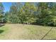 A lush backyard with a shed, a barrel, and tall trees at 320 Creekside Trl, Covington, GA 30016
