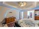 Large bedroom features a ceiling fan and tray ceilings with lighting at 320 Creekside Trl, Covington, GA 30016