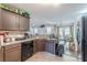 Traditional kitchen featuring brown cabinetry, tile floors, and an adjacent dining area with backyard access at 320 Creekside Trl, Covington, GA 30016