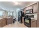 Well-lit kitchen features black appliances, dark cabinets, and tile flooring for a traditional feel at 320 Creekside Trl, Covington, GA 30016