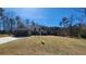 View of the home from the side, with a sprawling front lawn and mature trees surrounding the property at 275 Bridgemill Dr, Douglasville, GA 30134