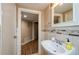 Bathroom with a single sink, mirror, and open doorway leading to another room at 17 Peachtree Ne Ave, Atlanta, GA 30305