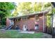 View of the brick house featuring an outdoor staircase, a cozy patio with chairs, and a well-maintained yard at 17 Peachtree Ne Ave, Atlanta, GA 30305