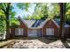 Quaint brick home with a gabled roof, surrounded by lush greenery and mature trees at 17 Peachtree Ne Ave, Atlanta, GA 30305