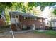 View of the brick house featuring an outdoor staircase, a cozy patio with chairs, and a well-maintained yard at 17 Peachtree Ne Ave, Atlanta, GA 30305
