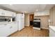 Kitchen featuring white cabinets, white refrigerator, and black appliances at 17 Peachtree Ne Ave, Atlanta, GA 30305