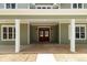 Inviting covered front porch with white columns, sconces and a striking wood double-door entrance at 529 Claude Scott Rd, Canton, GA 30115