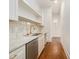 Bright butler's pantry with white cabinets, marble countertops, stainless steel dishwasher and hardwood flooring at 529 Claude Scott Rd, Canton, GA 30115