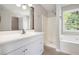 Bright bathroom with tub and shower, single vanity, and a view of the backyard at 221 Makayla Way, Temple, GA 30179