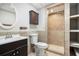 Bathroom featuring walk-in shower and vanity with cabinet, accented by neutral tile at 221 Makayla Way, Temple, GA 30179