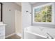 Bathroom featuring a soaking tub, walk-in shower, and a large window at 221 Makayla Way, Temple, GA 30179