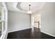 Dining room features a tray ceiling, hardwood floors, large window, and an open doorway to the living room at 221 Makayla Way, Temple, GA 30179