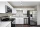 Modern kitchen with stainless steel appliances, granite countertops, and white cabinetry at 221 Makayla Way, Temple, GA 30179