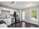 Bright kitchen features white cabinets, stainless steel appliances, granite countertops, and a view of the backyard at 221 Makayla Way, Temple, GA 30179