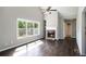 Inviting living room with a cozy fireplace, built-in shelves, large windows, hardwood floors, and a vaulted ceiling at 221 Makayla Way, Temple, GA 30179