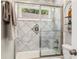 Bright bathroom featuring a tiled shower-over-tub with glass doors and a window for natural light at 517 Daniel Ave, Decatur, GA 30032