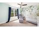 Charming Bedroom with a soft color palette, leafy wall-covering and a comfortable rocking chair at 517 Daniel Ave, Decatur, GA 30032