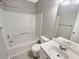 Clean bathroom featuring a tub with shower, single sink vanity and a bright white tile surround at 12 Bonnie Glen Ln, Hampton, GA 30228