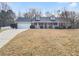 Charming brick home features a well-manicured lawn, attached garage, and inviting front porch at 12 Bonnie Glen Ln, Hampton, GA 30228