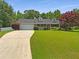 Charming home featuring a well-manicured lawn, mature trees, and a long driveway at 12 Bonnie Glen Ln, Hampton, GA 30228