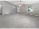 Empty living room featuring fresh gray paint, plush carpet, ceiling fan, and a window to brighten up the space at 12 Bonnie Glen Ln, Hampton, GA 30228