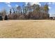 A spacious backyard featuring a large grass area, a tree line, and a partial fence at 871 Dunning St, Marietta, GA 30060