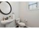 Powder room featuring a pedestal sink with a round mirror and a window for natural light at 871 Dunning St, Marietta, GA 30060