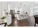 Bright white kitchen featuring stainless steel appliances, marble countertops, and barstool seating with elegant pendant lighting at 871 Dunning St, Marietta, GA 30060