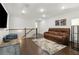 A cozy bonus room with a brown leather sofa, rug, TV, and staircase with decorative iron spindles at 871 Dunning St, Marietta, GA 30060